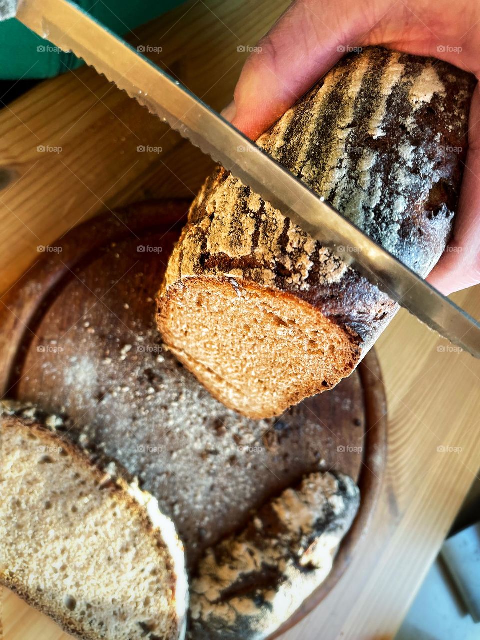 Close up of fresh dark bread being sliced