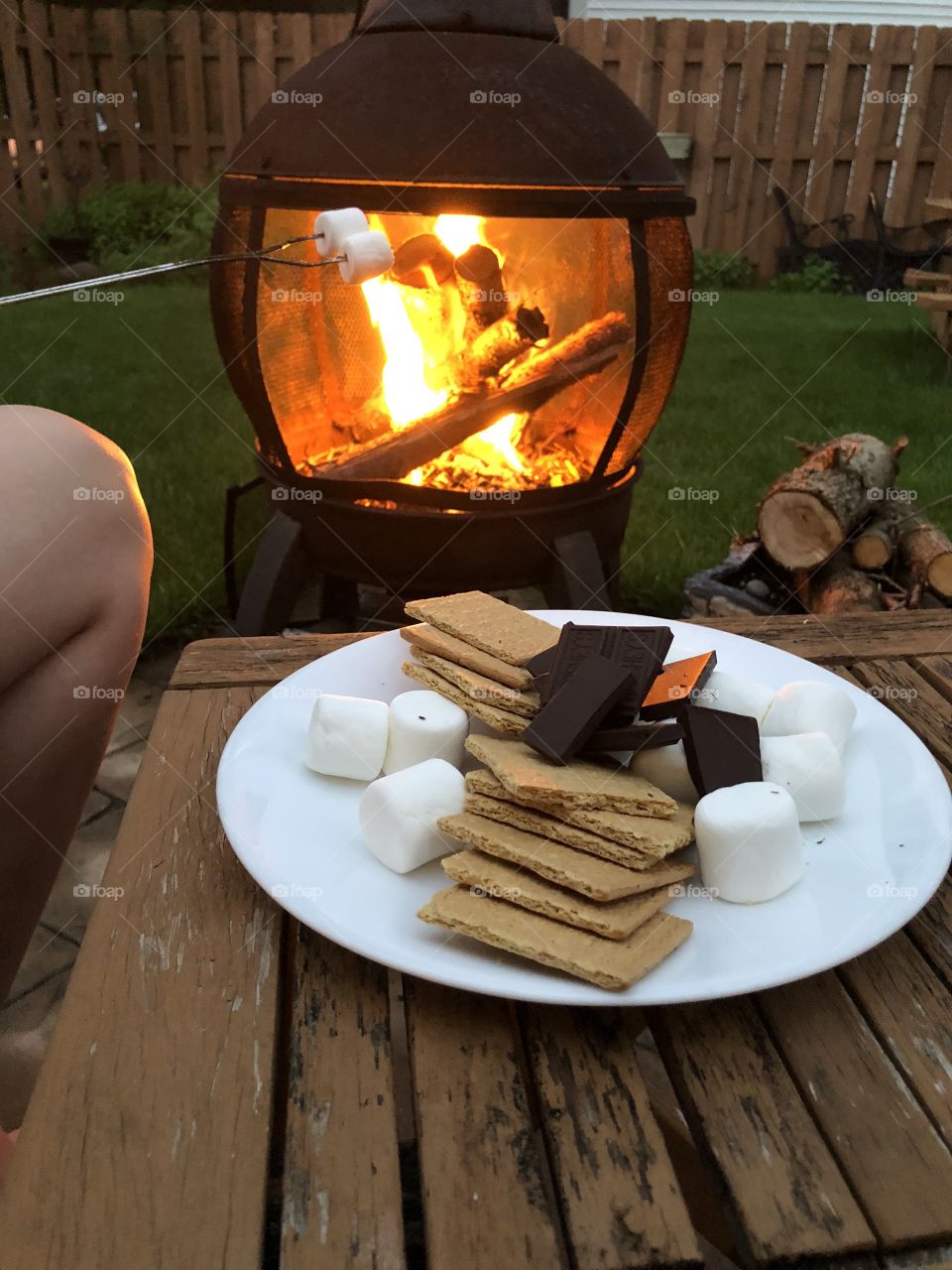 Backyard fire pit roasting marshmallows and making s’mores.