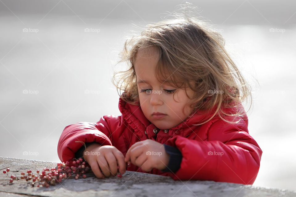 Girl in Red Jacket playing with Berries