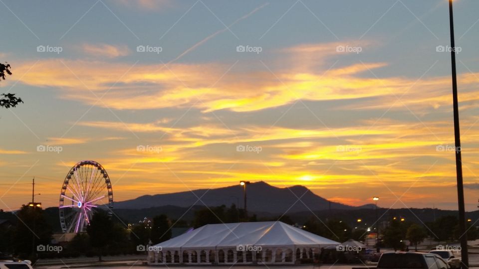 Farris wheel, sunset, tent and mountain