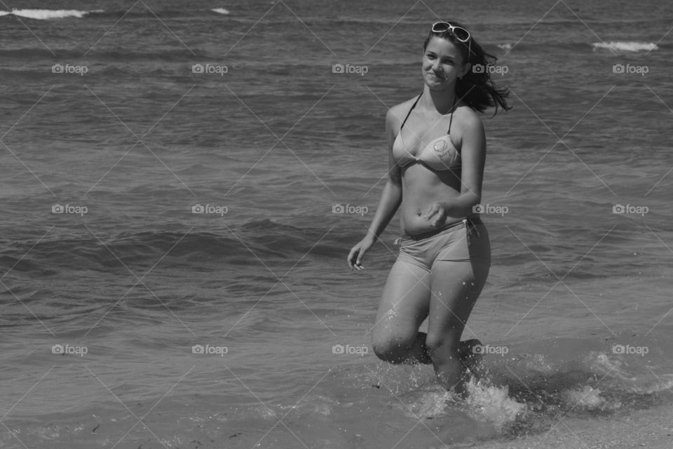 Attractive woman in biking walking in sea