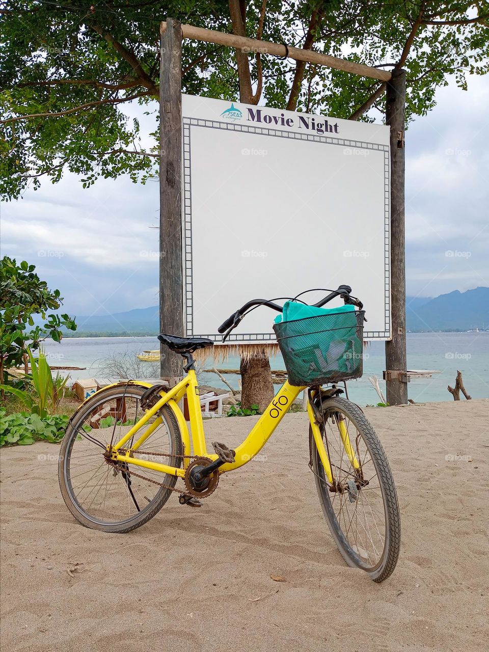 Yellow bicycle in front of movie night on the beach