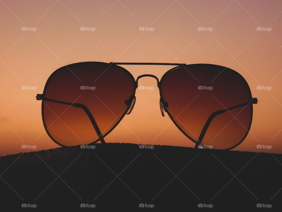 sunglasses silhouette image with sunset light background
