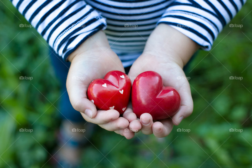 Close-up of a girl's hand with heart shape toys
