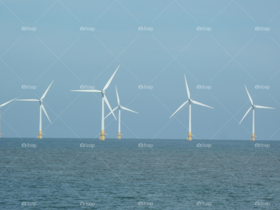sky blue sea wind turbines by raallwright