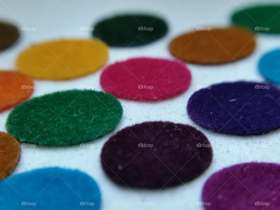 Dots through microlense. Colorful fabric dots are called Bindis in India