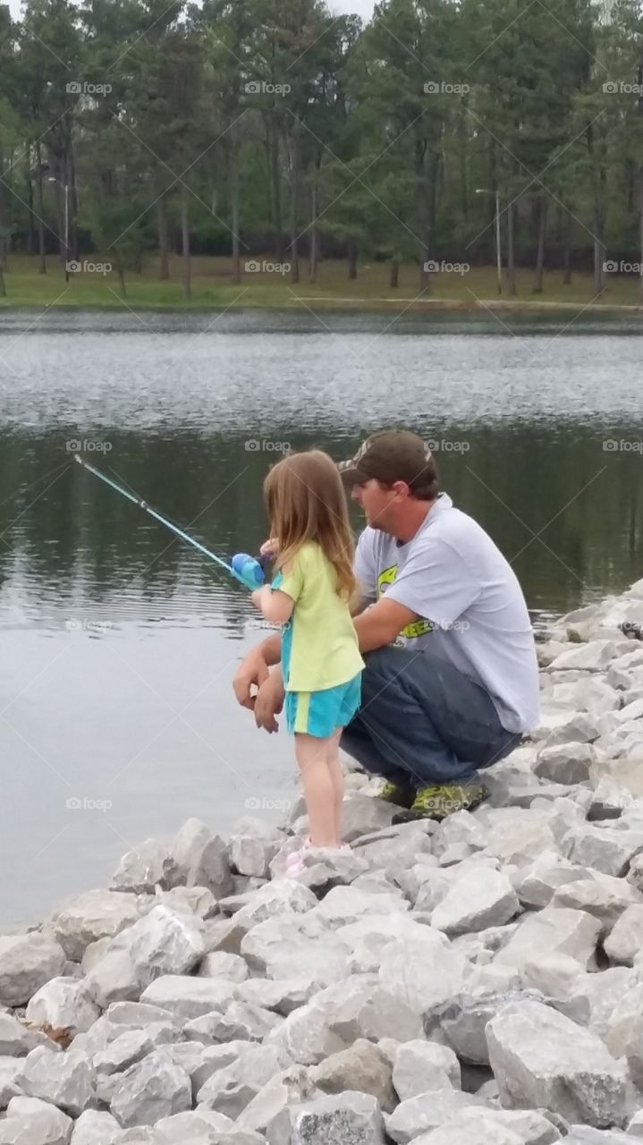 Dad and Daughter. Dad teaches daughter to fish