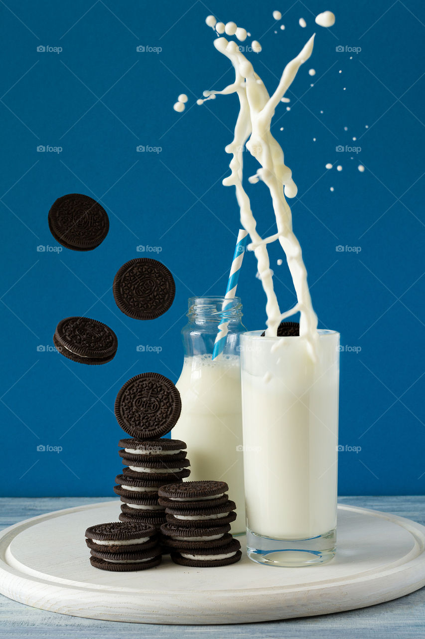 Oreo cookies and milk on blue background