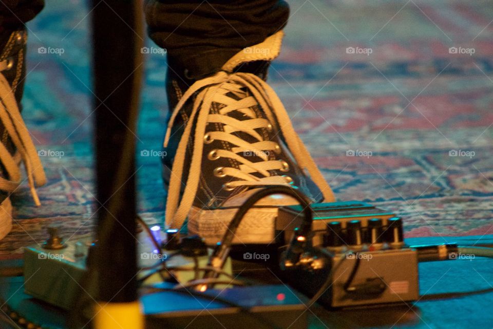 Punk rocker with foot on guitar pedal. 