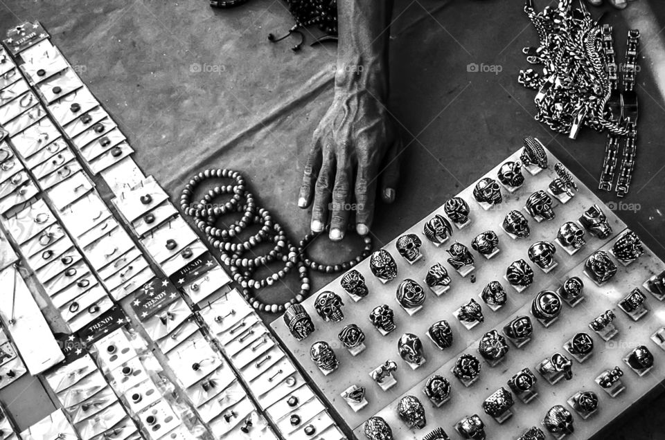 A merchant is managing his goods in the form of various types of rings on the roadside