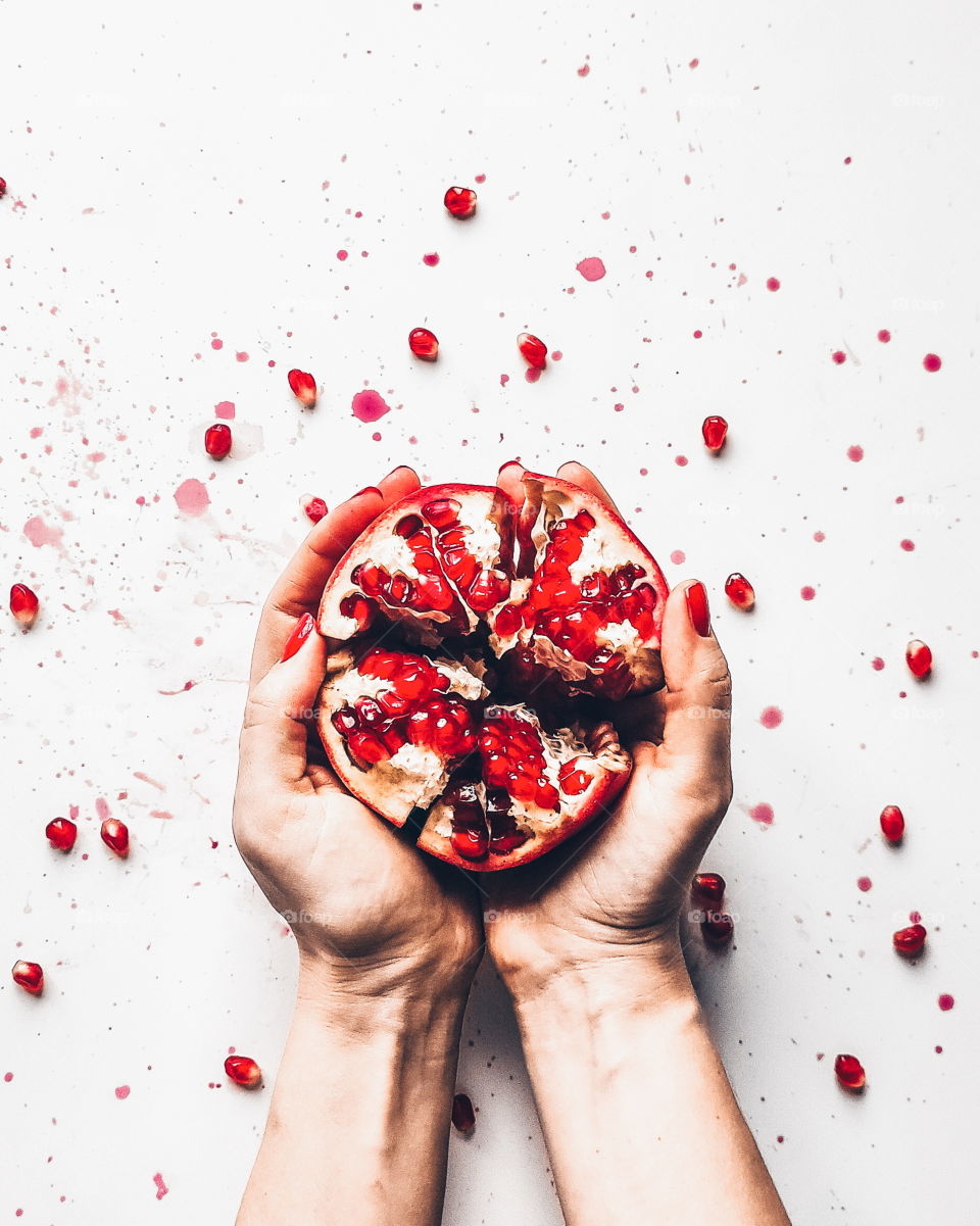 The fruit of the pomegranate in the woman hands