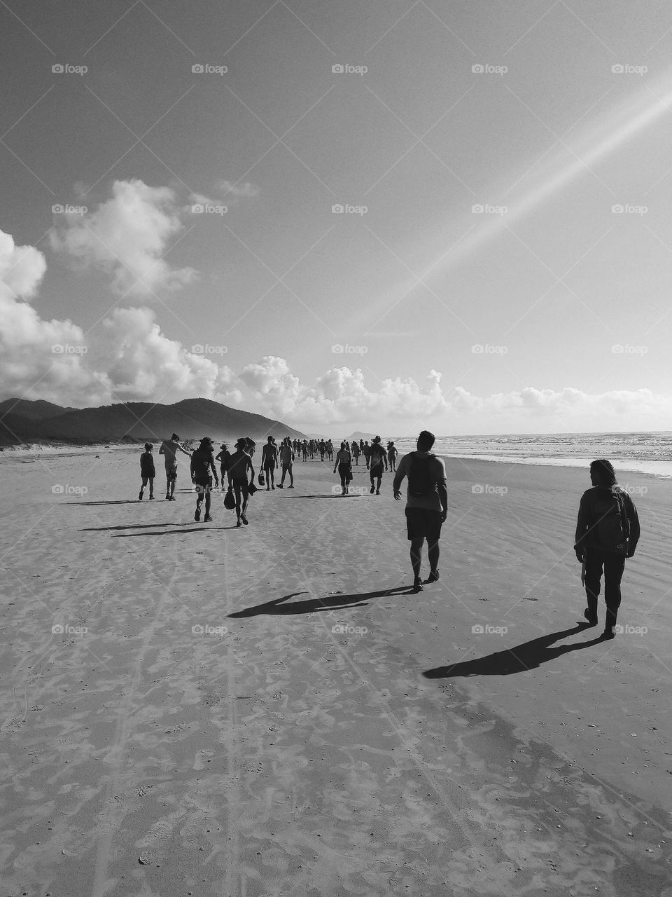 A very large group of people walking on the beach, at Cardoso's Island, Ilha do Cardoso, Brasil.
A beautiful sunny day at the beach, in a black and white photo.