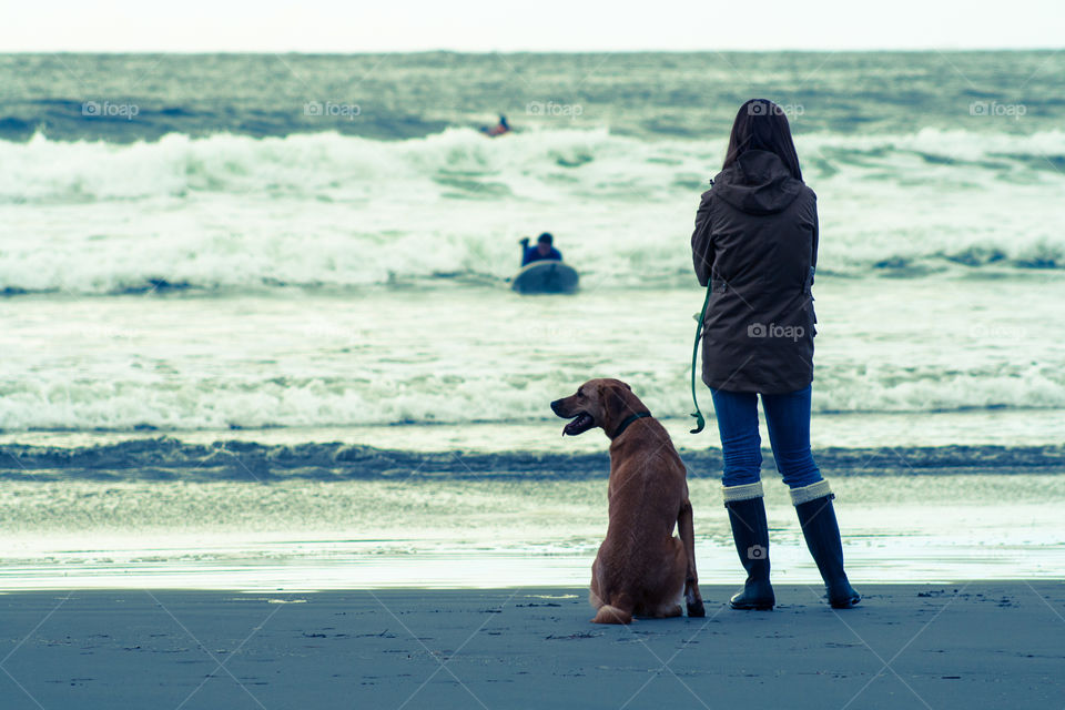 Woman standing on beach with dog