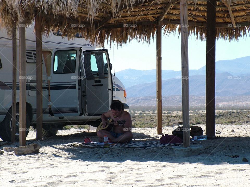 practicing guitar on a beach