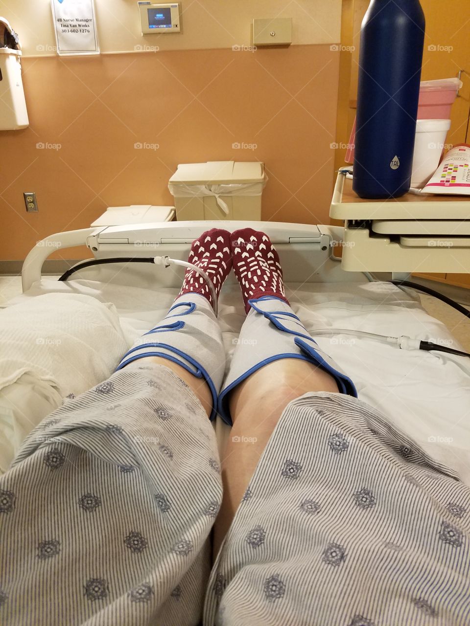 Legs, post surgery, laying in a hospital bed with pressure cuffs that are designed to keep you from getting blood clots.
