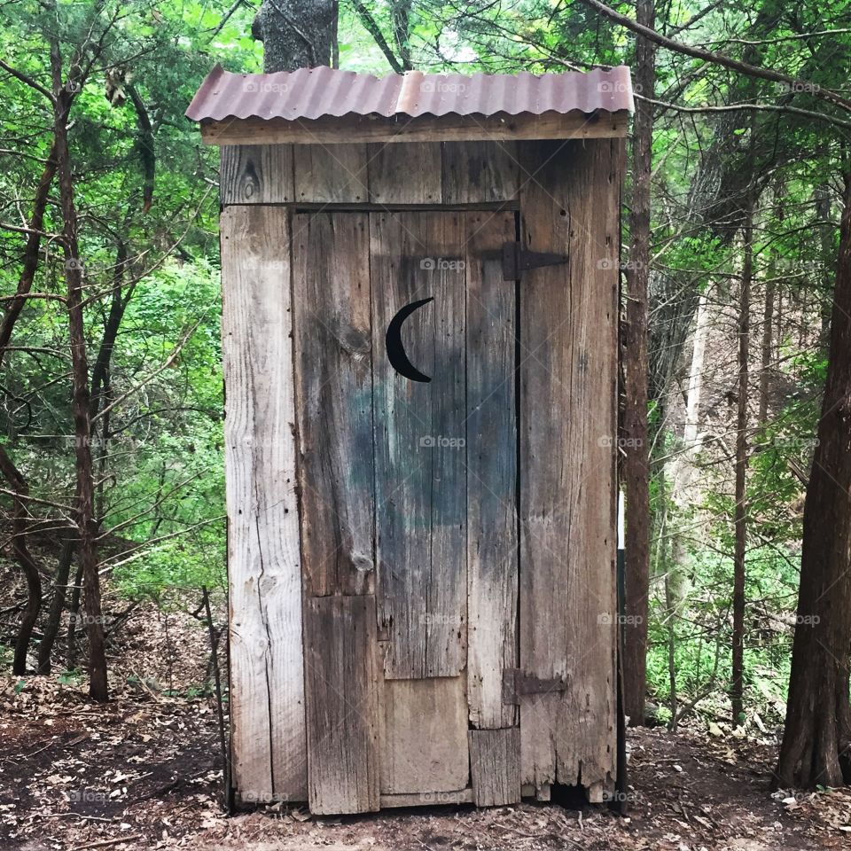 Rustic old outhouse in the woods