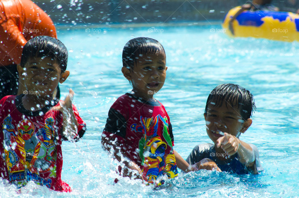 Asian people enjoying in swimming pool