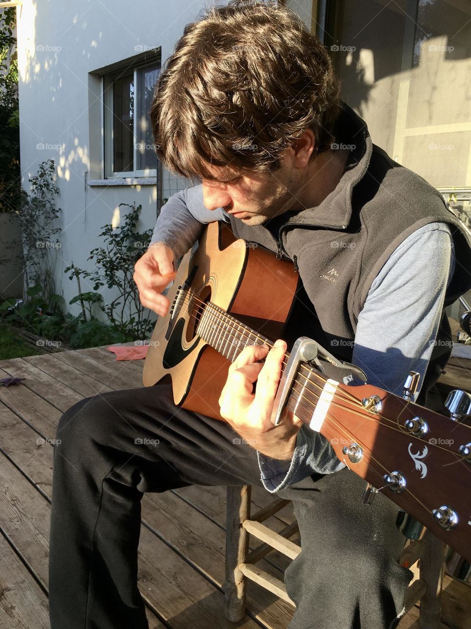 Father playing guitar with afternoon sunshine 