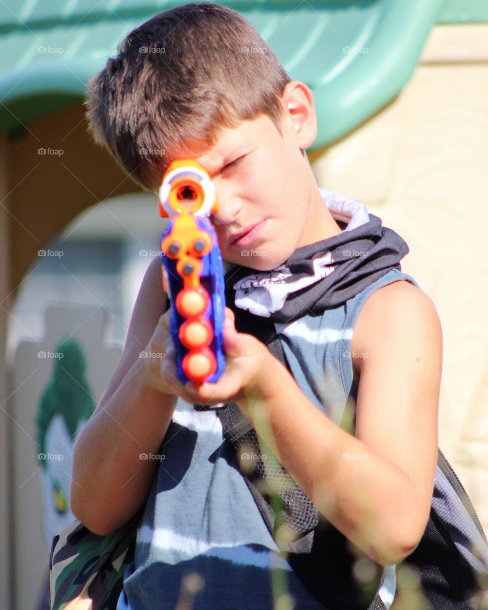A little boy with gun toy