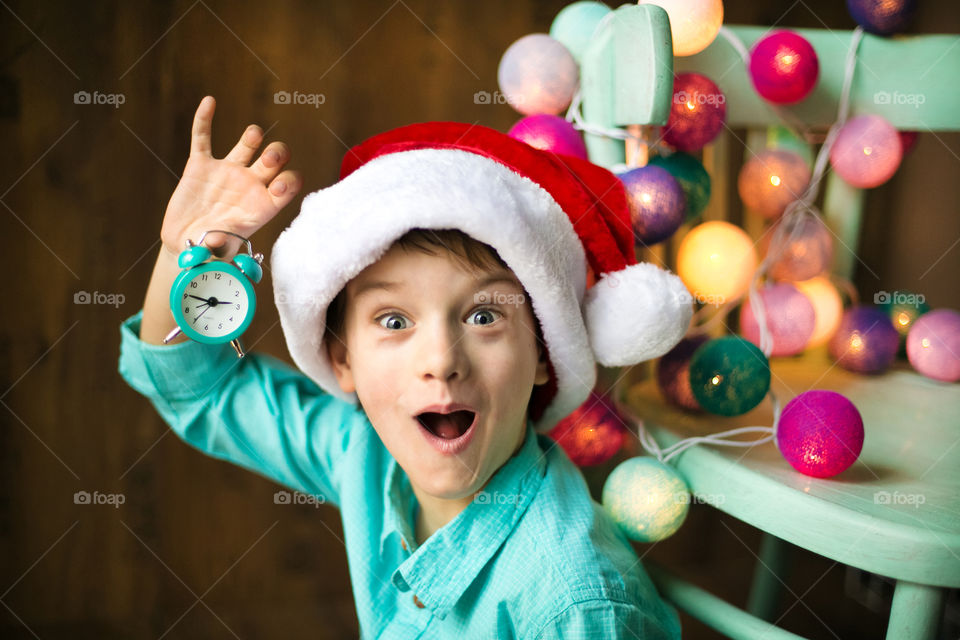 Boy wearing christmas with alarm clock