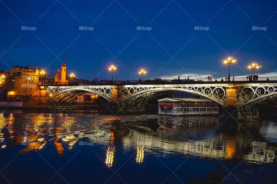 Seville river, boat & bridge at dusk