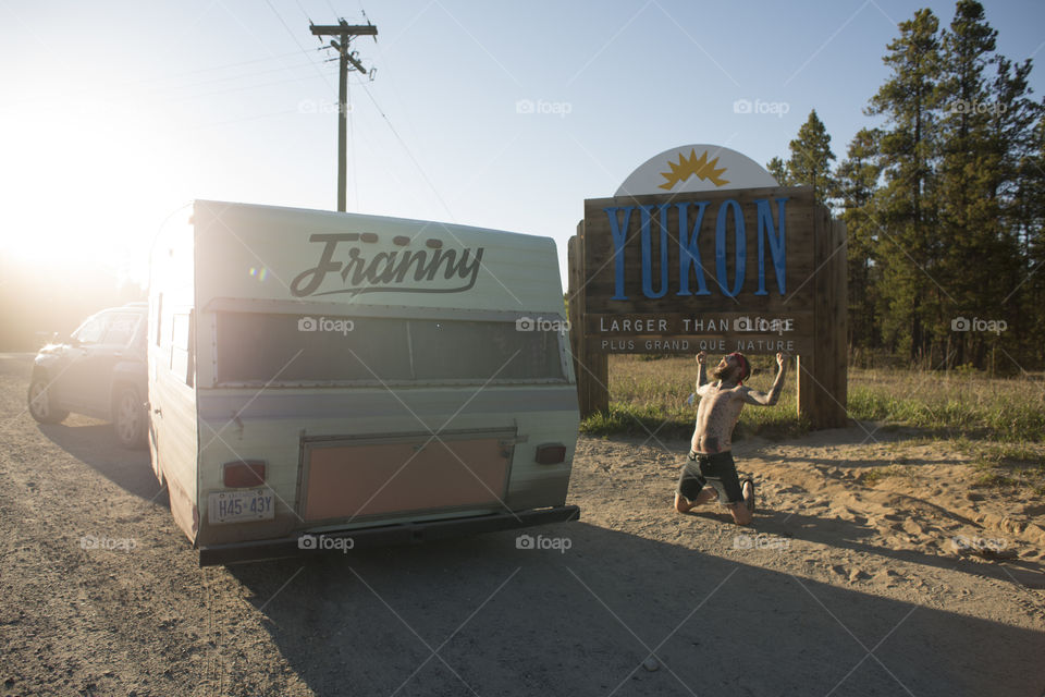 Travel Trailer and Hipster in front of Yukon Sign