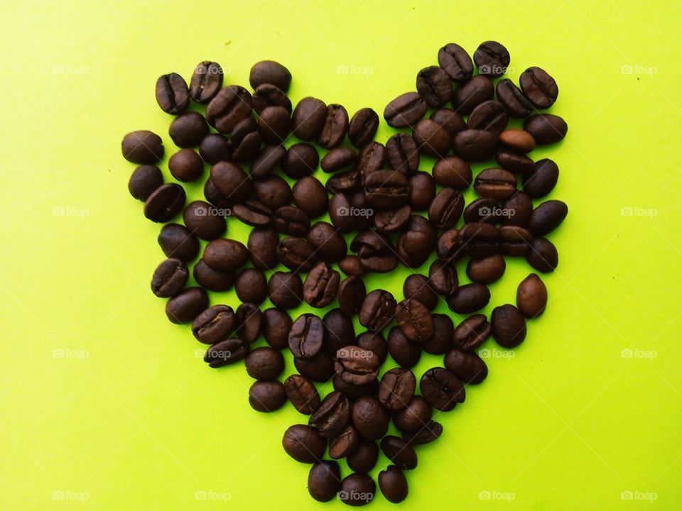 heart made of coffee beans on a yellow background