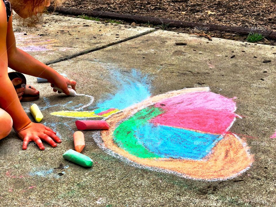 Child Drawing a Heart with Sidewalk Chalk 