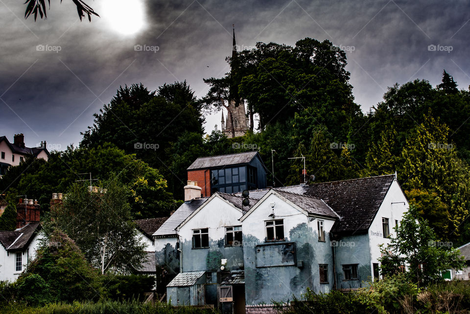 The old house, showing mood set clouds on a greying old derelict building ebbing away slowly.