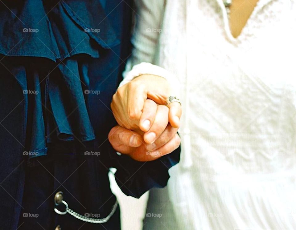 Close-up of man and woman holding hands