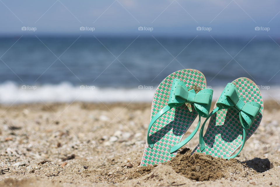 flip flops on beach. flip flops stuck in sand on beach