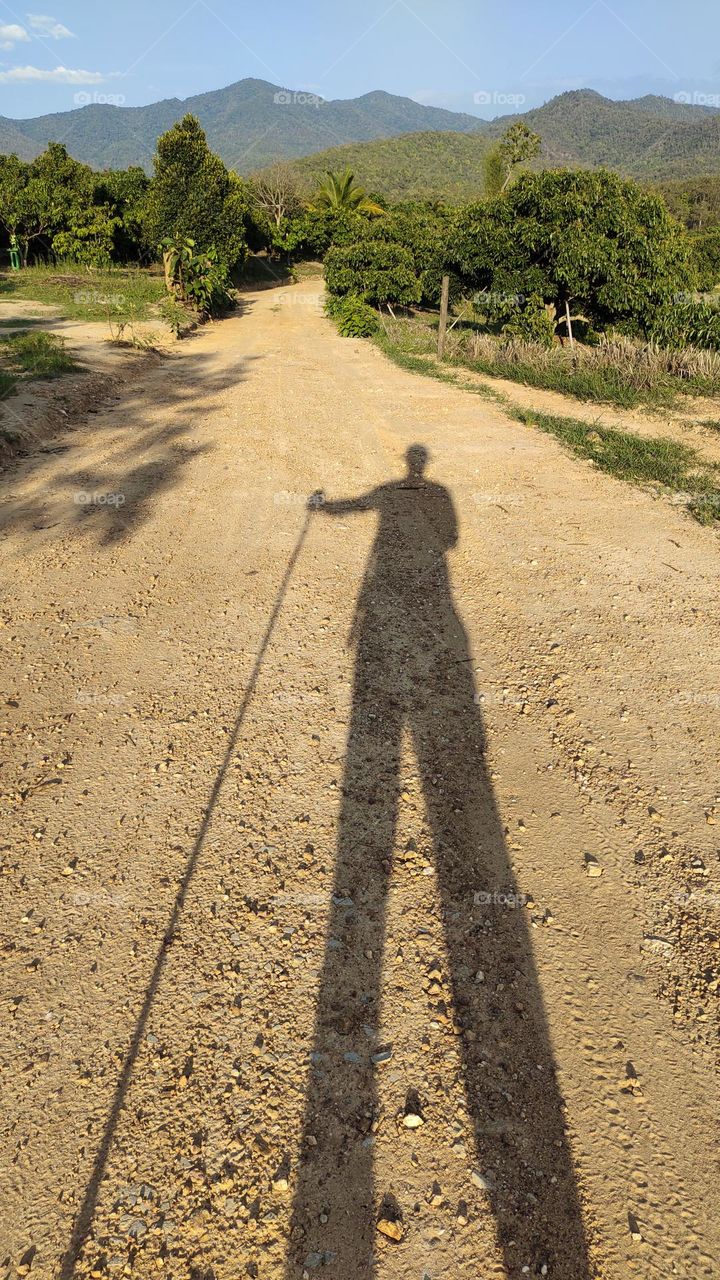 Shadow of a man during hiking trip in front of mountain