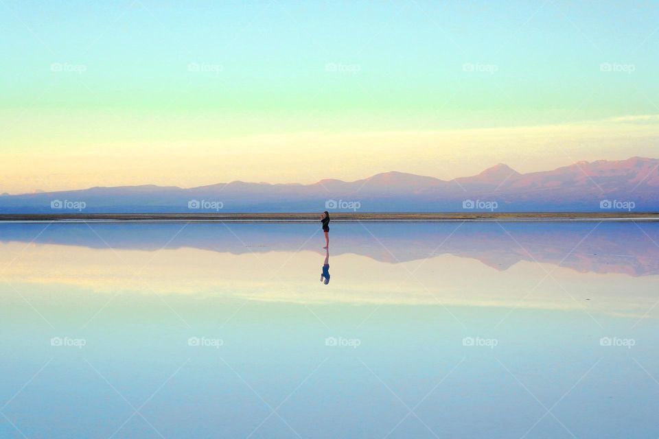 Beautiful reflection of a man by the calm ocean.