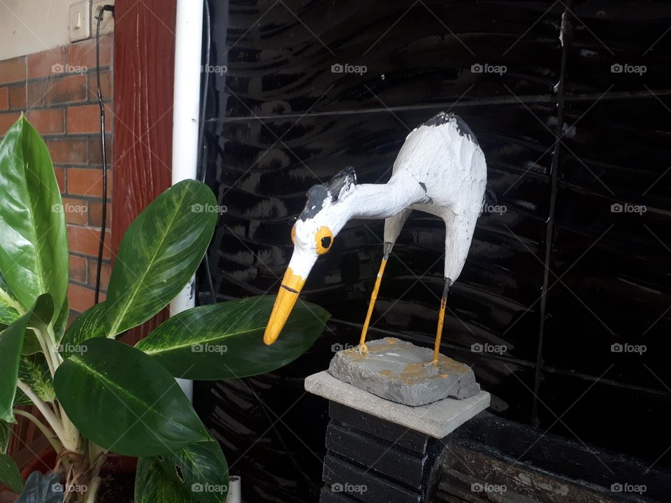 white swan-shaped statue which is located above the fish pond