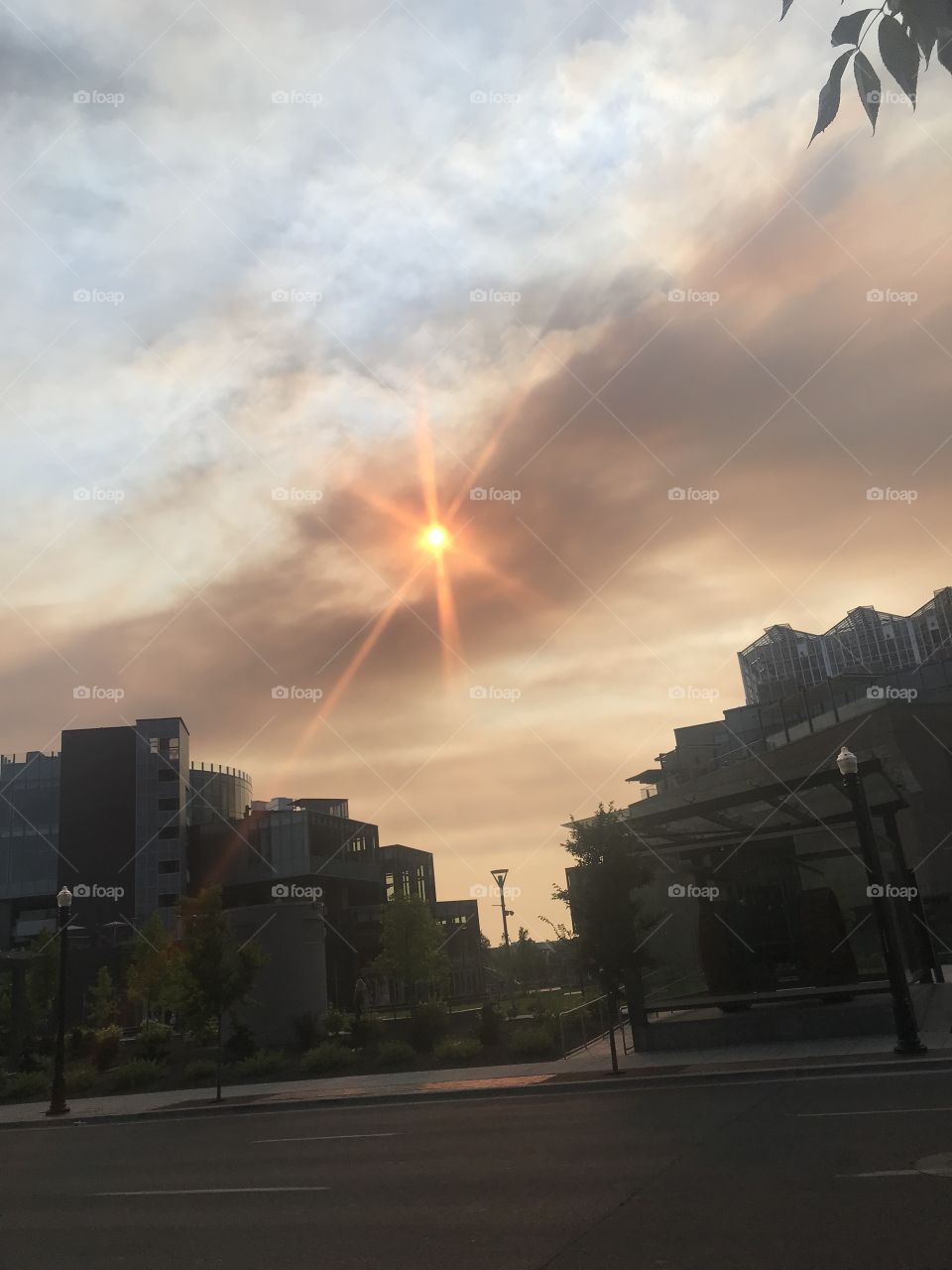 The sun is glowing red in beautiful downtown Boise, taken between two industrial buildings in the heart of the city. 