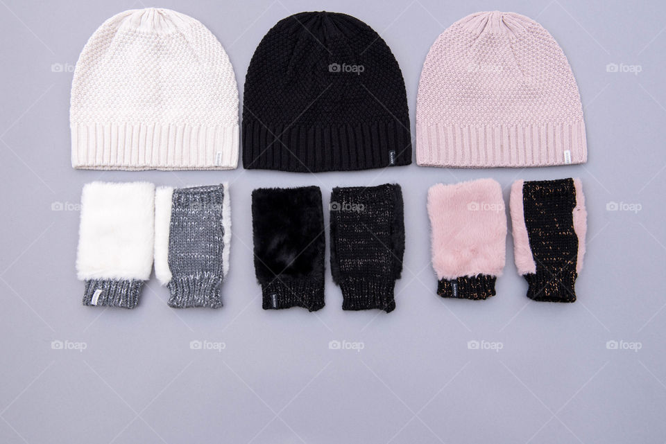 Flat lay of three pairs of beanie hats and fingerless gloves