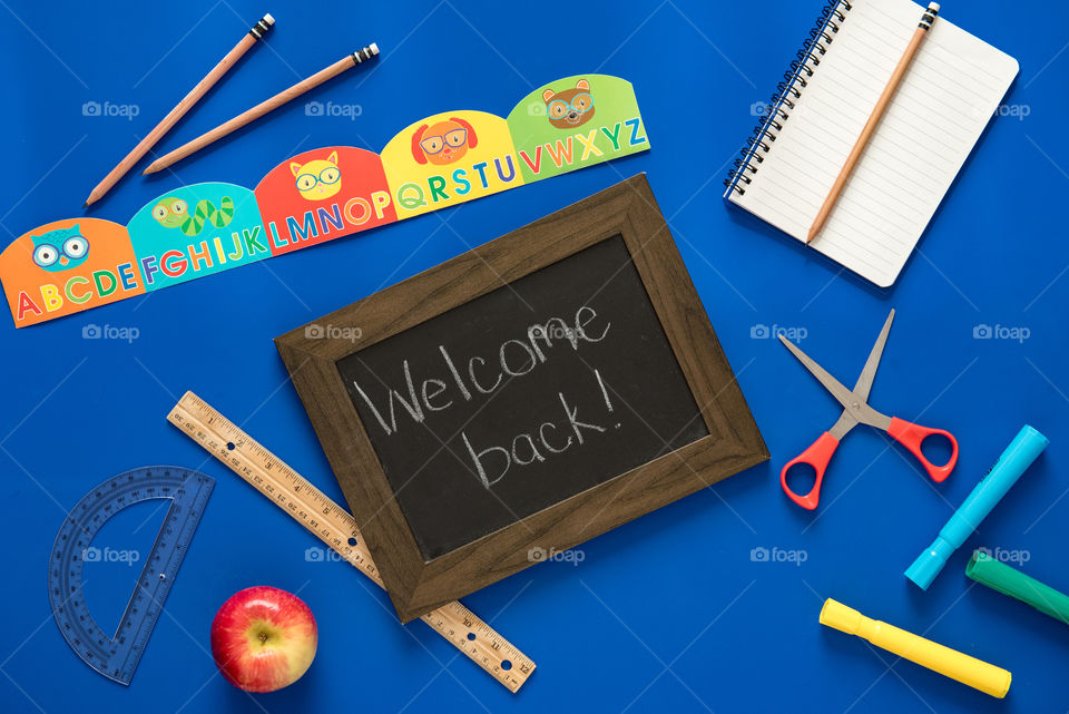 Flat lay of a welcome back sign and school supplies 