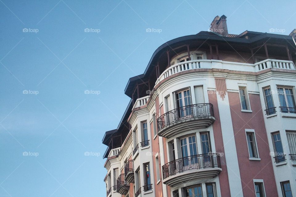 Taken in Annecy, France. A lovely and beautiful vintage French building sits on a clear blue sky