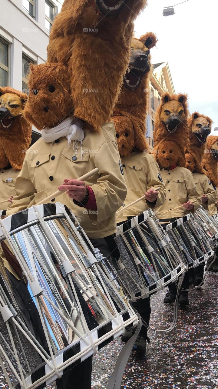 a large crowd of people running in the city among large buildings. a crowd of people in masquerade costumes and masks at a fundamental festival in Switzerland. people in bright costumes on a holiday