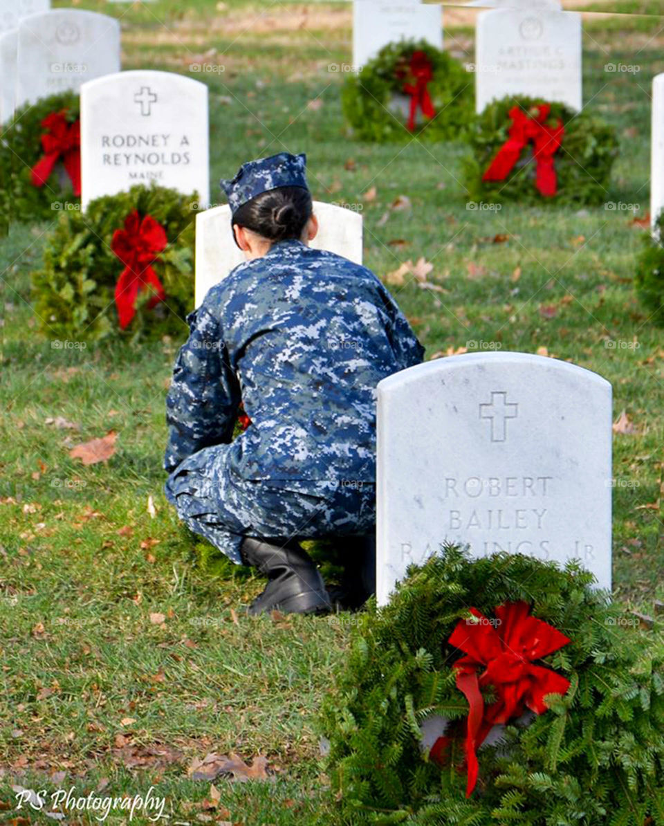 volunteer placing wreath. wreaths across America at Arlington national cemetery