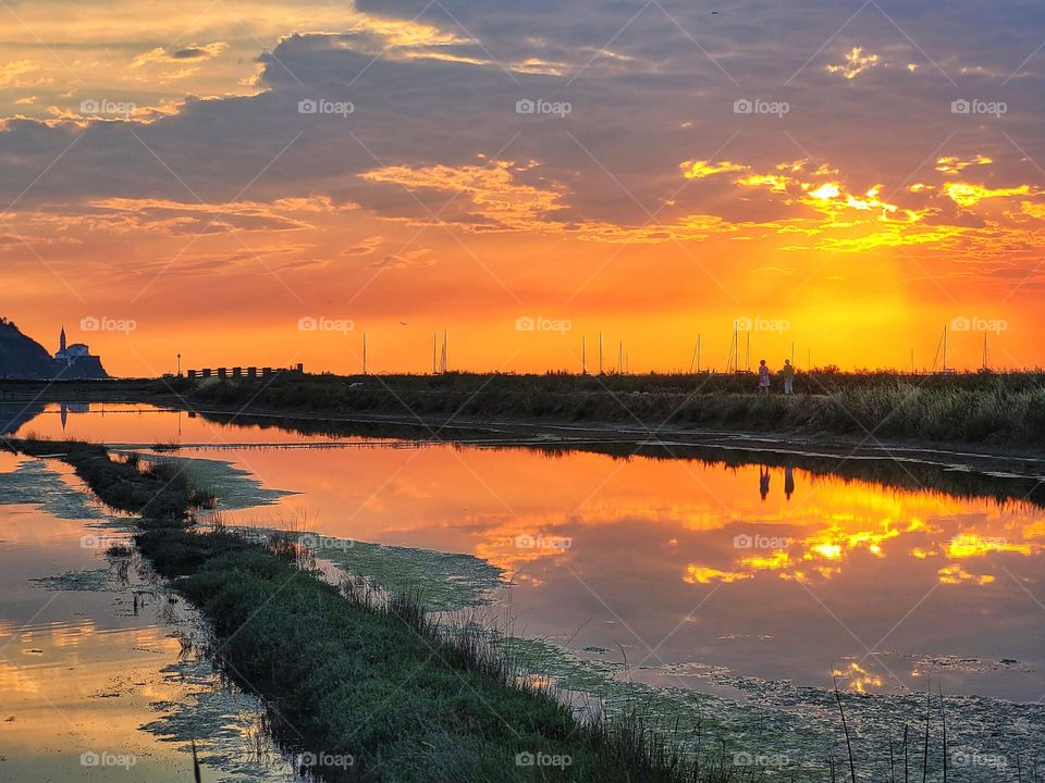 Scenic view of Adriatic sea, coast against orange sunset sky in Slovenia. Summer time. Vacation. Landscape.