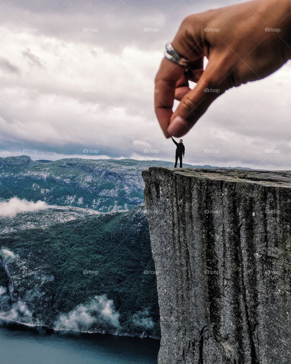 Big hand holding little human at Prekestolen in Norway