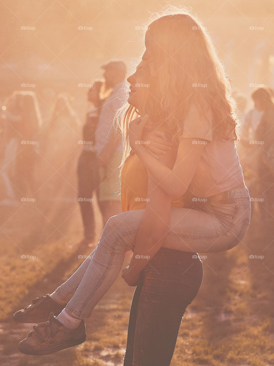 Portrait of happy smiling young girls with colorful paints on faces and clothes. Two friends spending time on holi color festival. Real people, authentic situations