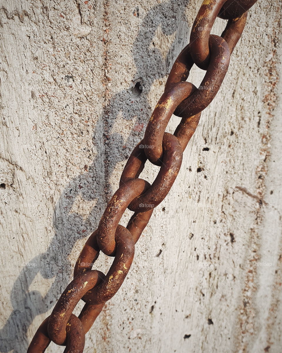 Rusty chain against concrete (portrait orientation)