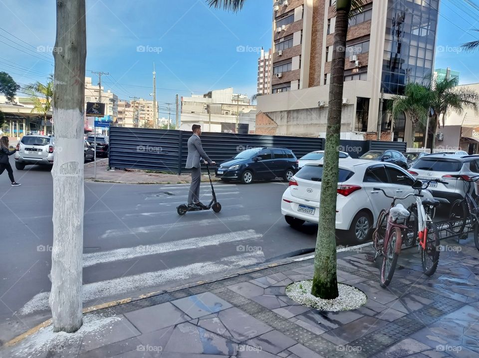 Executive man riding a scooter