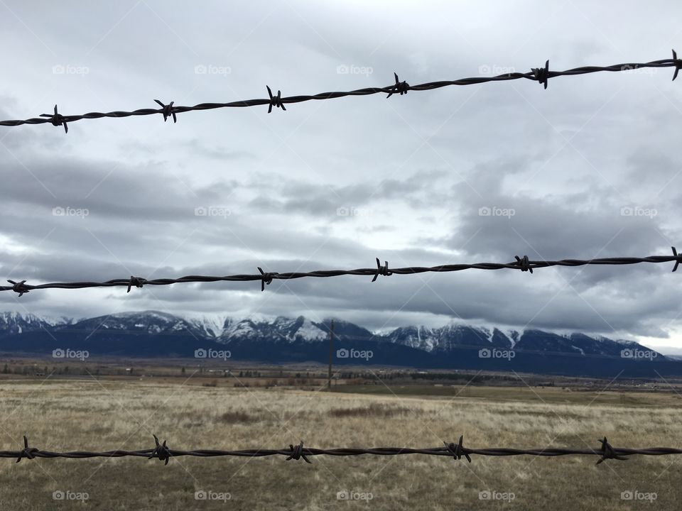 Mission Mountains through the barbed wire fence in the National Bison Range. 