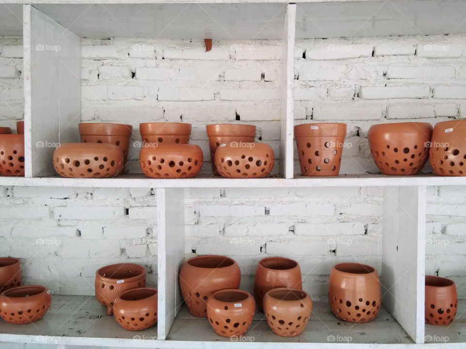 pottery displayed on white brick wall