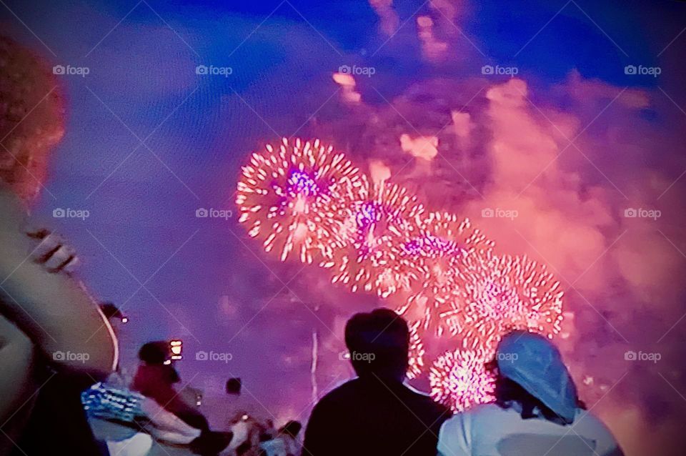 Spectators enjoying exploding fireworks.