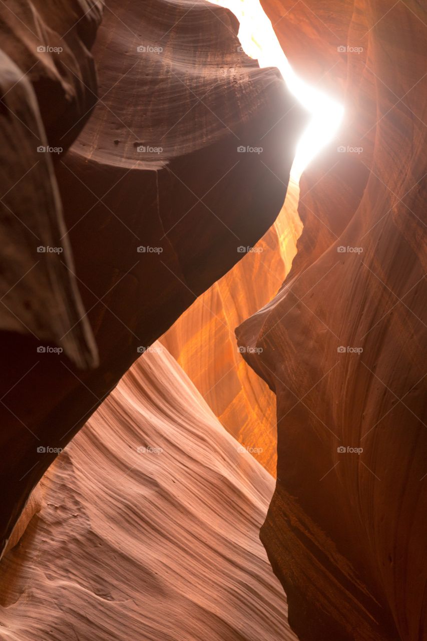 Looking up from slot canyon. Looking up from Antelope slot canyon. Deep shadows and colorful red rocks. Sky and sun visible via crack