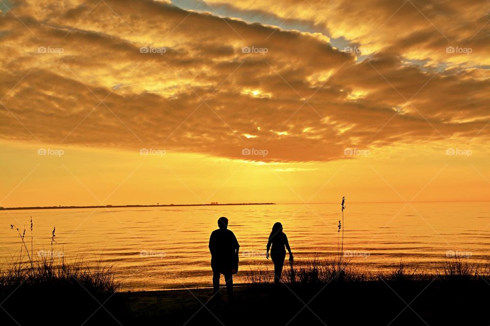 Walking along the beach - The horizon erupted in spectacular golden hues of orange moments before the sun sunk below the horizon giving the viewers a fabulous and unforgettable sunset.